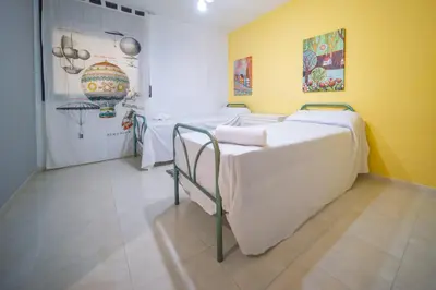 a hospital room with three beds and a yellow wall at HomeHolidaysRentals Milos - Costa Barcelona in Pineda de Mar
