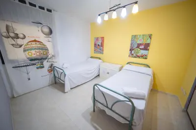 a hospital room with two beds and a yellow wall at HomeHolidaysRentals Milos - Costa Barcelona in Pineda de Mar