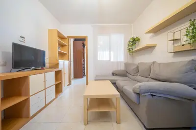 a living room with a couch and a tv at HomeHolidaysRentals Milos - Costa Barcelona in Pineda de Mar