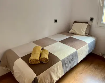 a bedroom with a bed with two towels on it at Large Apartment near FIRA and City Center in Hospitalet de Llobregat