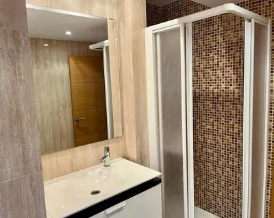 a bathroom with a sink and a mirror at Large Apartment near FIRA and City Center in Hospitalet de Llobregat