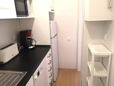 a small kitchen with a refrigerator and a microwave at ApartEasy - Atic Sants in Barcelona
