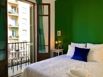 a green bedroom with a bed and a balcony at LEPANTO APARTMENTS 150m FROM SAGRADA FAMILIA in Barcelona