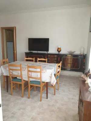 a dining room with a table and chairs and a television at Appartement 6 Personnes - L'arboc in Arbós