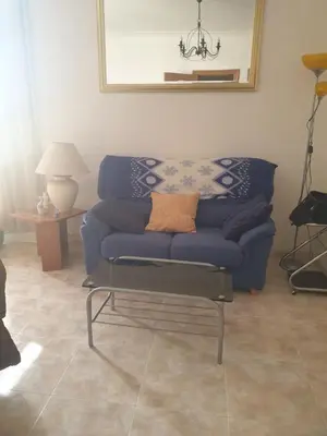 a living room with a blue couch and a table at Appartement 6 Personnes - L'arboc in Arbós