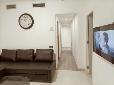 a living room with a couch and a clock on the wall at Molino Fresh in Barcelona