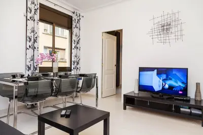 a living room with a tv and a table and chairs at Molino Fresh in Barcelona