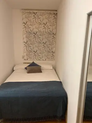 a small bedroom with a bed with a wall at Modernismo Paseo de Gracia in Barcelona