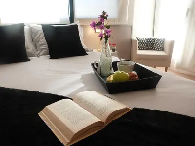 an open book and a bowl of fruit on a bed at Ca la Carmeta in Cunit