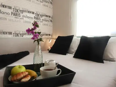 a tray of fruit and a cup of coffee on a bed at Ca la Carmeta in Cunit