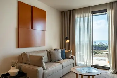 a living room with a couch and a large window at Sabàtic Sitges Hotel, Autograph Collection in Sitges