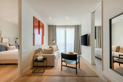a living room with a couch and a bed and a mirror at Sabàtic Sitges Hotel, Autograph Collection in Sitges