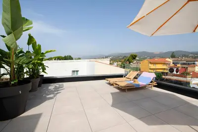 a balcony with a couch and chairs on a roof at Apartamentos Balisse in Castelldefels