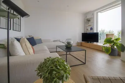 a living room with a couch and a tv at Vivalidays Apartour - Calella in Calella
