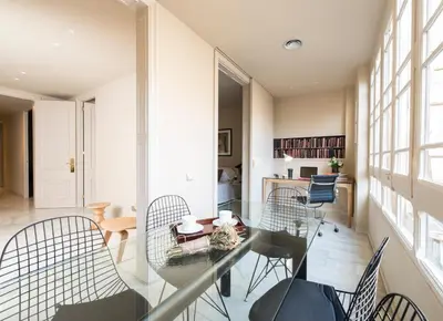 a dining room with a glass table and chairs at Glocal Apartments Barcelona in Barcelona
