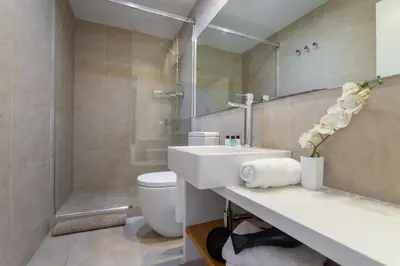 a bedroom with two beds and a mirror at The Collection Barcelona - 3-bedroom penthouse with terrace in Eixample in Barcelona