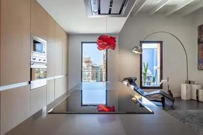 a living room with a glass table and a window at The Collection Barcelona - 3-bedroom penthouse with terrace in Eixample in Barcelona