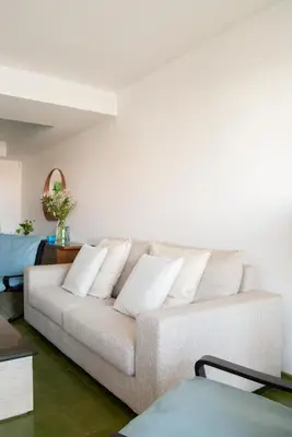 a white couch with white pillows in a living room at Apartment near the beach and Port Marina of Premia in Premiá de Mar