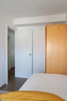 a bedroom with a bed and a wooden cabinet at Apartment near the beach and Port Marina of Premia in Premiá de Mar
