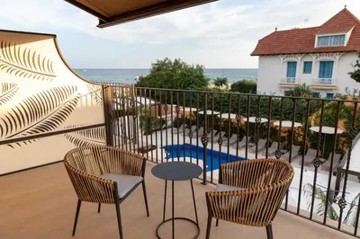 a balcony with chairs and a table and a view of the ocean at AB BOUTIQUE HOTEL - Adults only in Sant Vicenç de Montalt