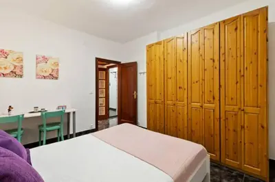 a bedroom with a bed with wooden cabinets and a desk at Stay U-nique Apartments La Bordeta in Barcelona