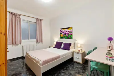 a bedroom with a bed with purple pillows and a table at Stay U-nique Apartments La Bordeta in Barcelona