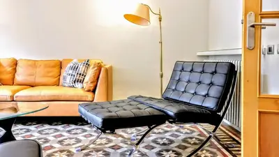 a living room with a chair and a couch at BizFlats Eixample Apartments in Barcelona