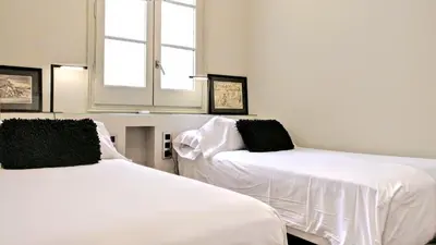 two beds sitting next to each other in a room at BizFlats Eixample Apartments in Barcelona