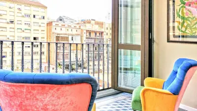 a room with two chairs and a large window at BizFlats Eixample Apartments in Barcelona