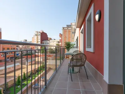 a balcony with a chair and a view of a street at Limehome Barcelona Carrer de Besalú 90 - estancia temporal in Barcelona
