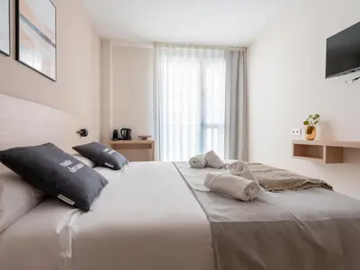 a bedroom with a large bed with two pillows on it at Limehome Barcelona Carrer de Besalú 82 in Barcelona