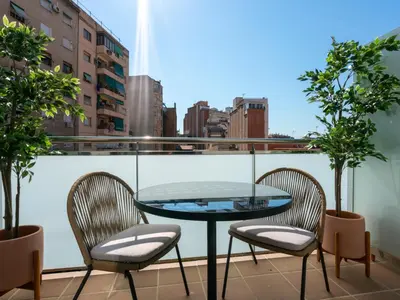 a glass table and two chairs on a balcony at Limehome Barcelona Carrer de Besalú 82 in Barcelona