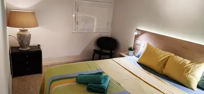 a bedroom with a bed and a lamp and a chair at Casa Petits in Manresa