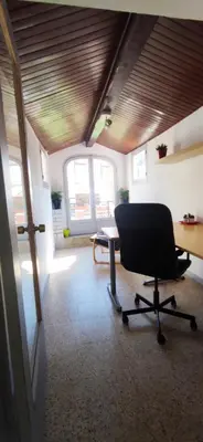 a office with a desk and a chair in a room at Casa Petits in Manresa