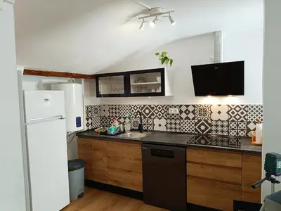a kitchen with a sink and a refrigerator at Casa Petits in Manresa