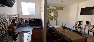 a kitchen and a dining room with a table and a room with at Casa Petits in Manresa