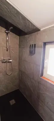 a shower in a bathroom with a window at Casa Petits in Manresa