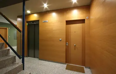 a wooden elevator door in a building with stairs at Mazi Apartments Downtown in Mataró