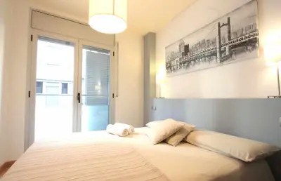 a bedroom with a large bed with a large window at Mazi Apartments Downtown in Mataró