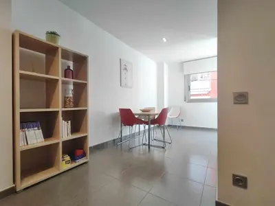 a living room with a table and a book shelf at Mazi Apartments Nest in Mataró