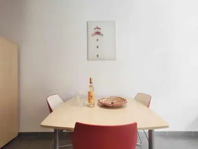 a table with chairs and a bottle of wine on it at Mazi Apartments Nest in Mataró