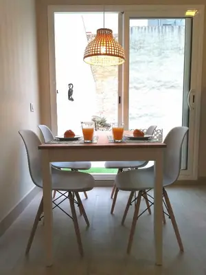 a dining room table with chairs and a chandelier at Mazi Apartments Penthouse in Badalona