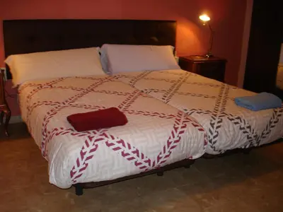 a bed with a red and white blanket on it at LA NURSERY DE MAS GUILLO in San Quintín de Mediona