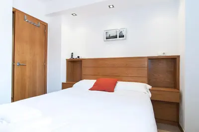a bedroom with a large bed with a wooden headboard at Private terrace at Sagrada Familia in Barcelona