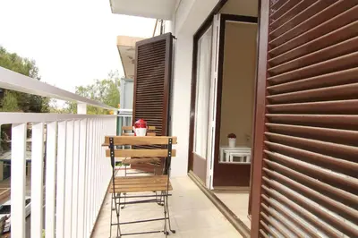 a porch with a chair and a table on a balcony at Rubí: Luminoso apartamento a 1 minuto de la playa in Sitges