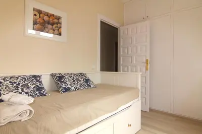 a bedroom with a bed with a picture on the wall at Rubí: Luminoso apartamento a 1 minuto de la playa in Sitges