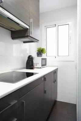 a white kitchen with a sink and a microwave at SAGRADA FAMILIA VIEWS Nos preocupa su seguridad. in Barcelona