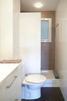 a white bathroom with a toilet and a bath tub at SAGRADA FAMILIA VIEWS Nos preocupa su seguridad. in Barcelona