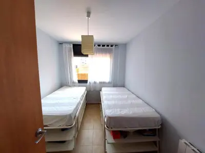 a small room with two beds and a window at BRAVAHOLIDAYS-201-Pineda in Pineda de Mar