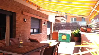 a patio with a wooden table and a dog house at BRAVAHOLIDAYS-201-Pineda in Pineda de Mar